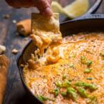 A skillet of Hot Vegan Crab Dip with a cracker pulling some out.