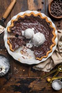 Molten vegan chocolate pie with vegan ice cream on top and slices removed.