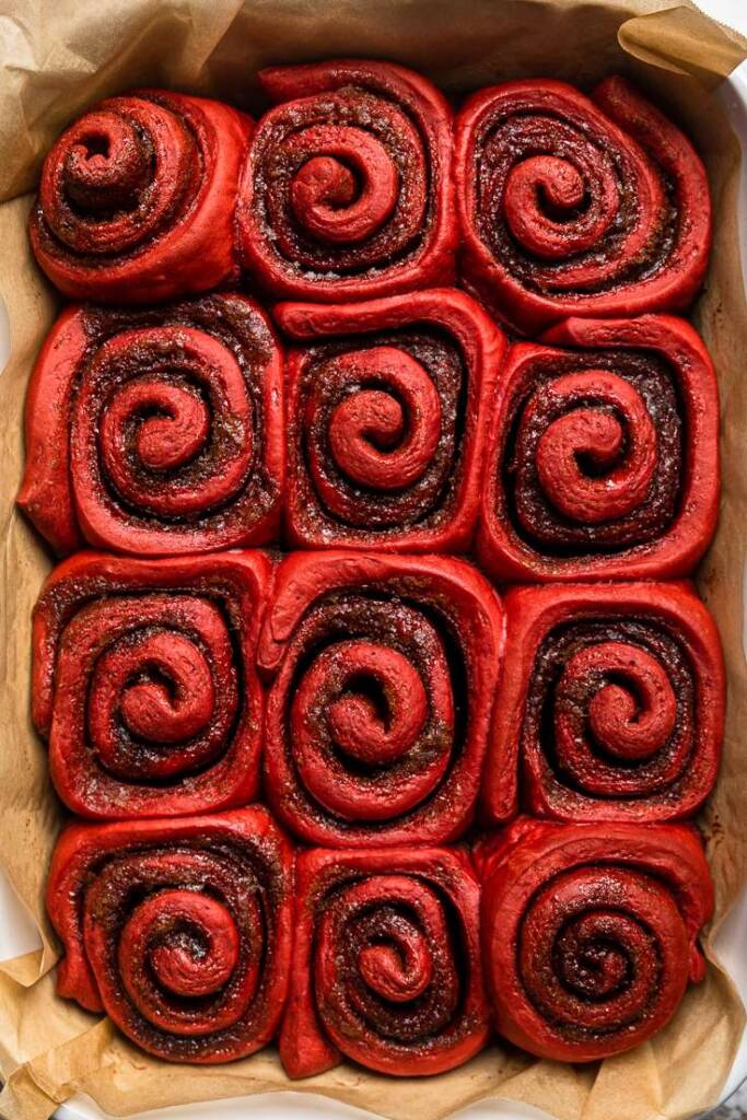 A cooked tray of vegan red velvet cinnamon rolls without frosting. 