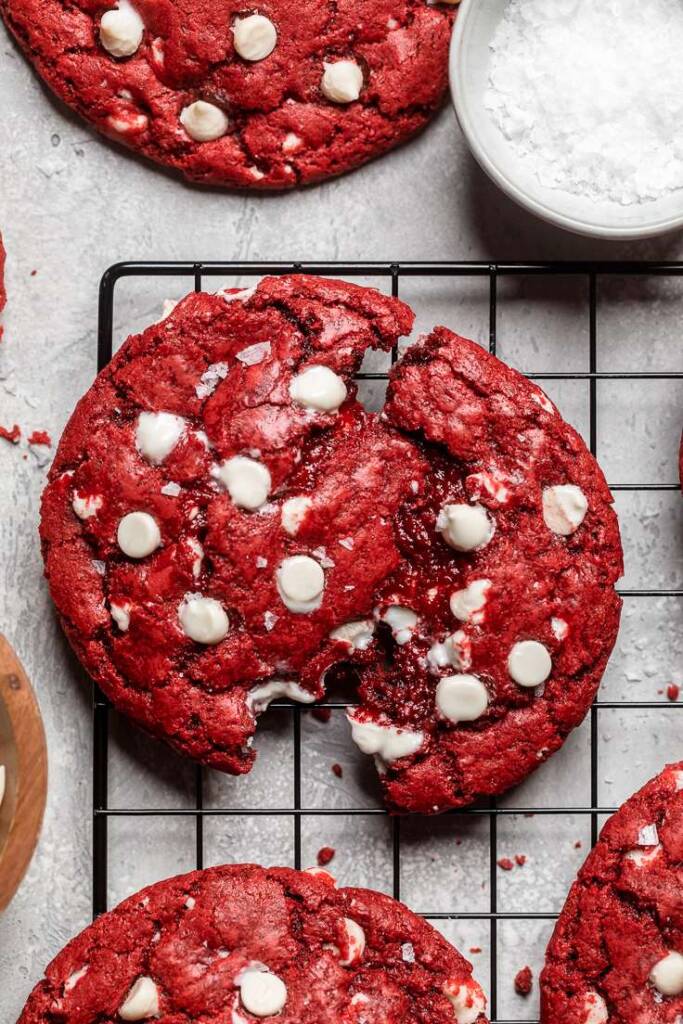 A close up of a broken vegan red velvet cookie to show gooey center. 