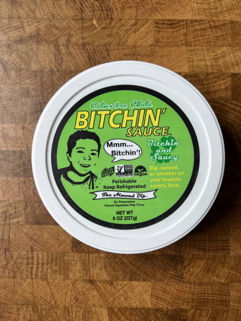 A container of cilantro chili bitchin\' sauce.