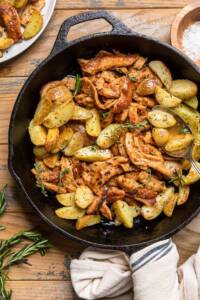 A skillet of vegan garlic butter chicken and potatoes in sauce