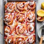 A tray filled with cooked Vegan Strawberry Cinnamon Rolls.