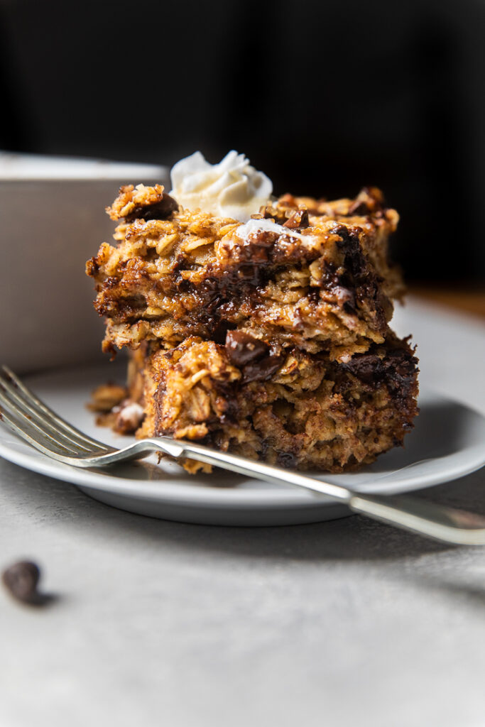 two pieces of vegan banana bread baked oatmeal stacked on a plate.