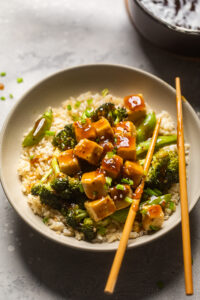 A bowl of Teriyaki Tofu and Broccoli with extra sauce on top.