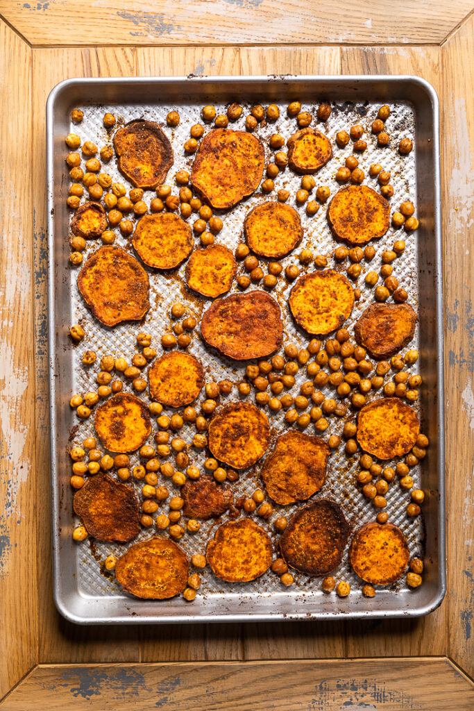 A sheet pan with crisp sliced sweet potatoes and chickpeas. 