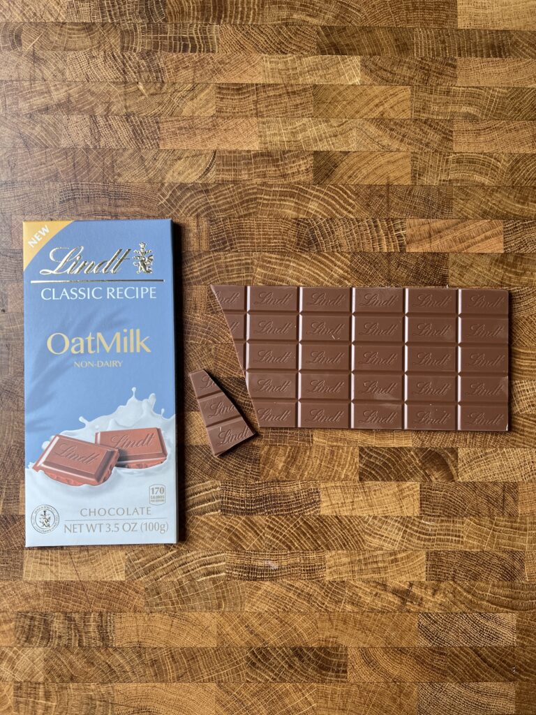 Lindt Oat Milk chocolate bar chopped with packaging beside. 