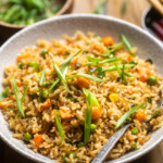 A bowl of vegan fried rice with mixed vegetables.