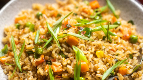 A bowl of vegan fried rice with mixed vegetables.