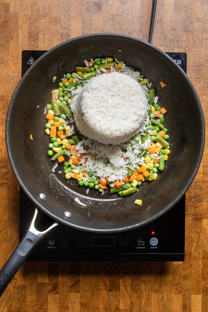 A skillet with mixed vegetable and rice. 