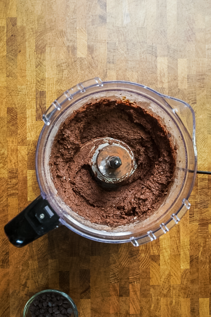 Eine Küchenmaschine mit gemischten Zutaten für gesunde vegane Brownies mit schwarzen Bohnen.