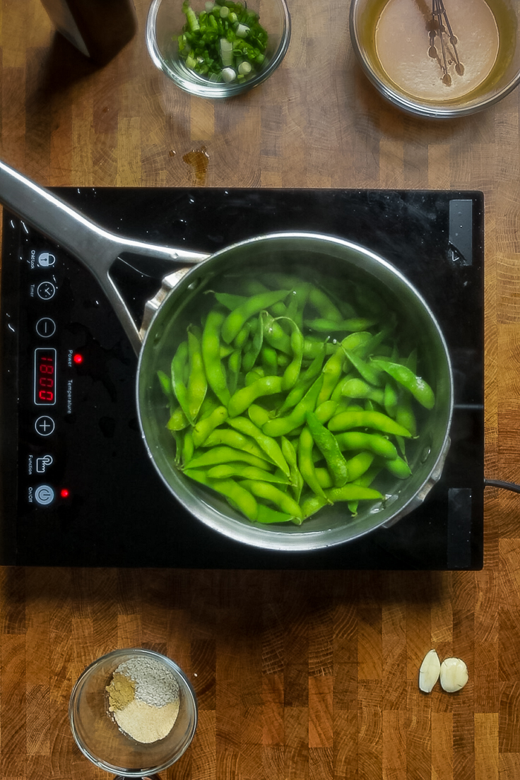 Edamame cooking in a pot of boiling water. 