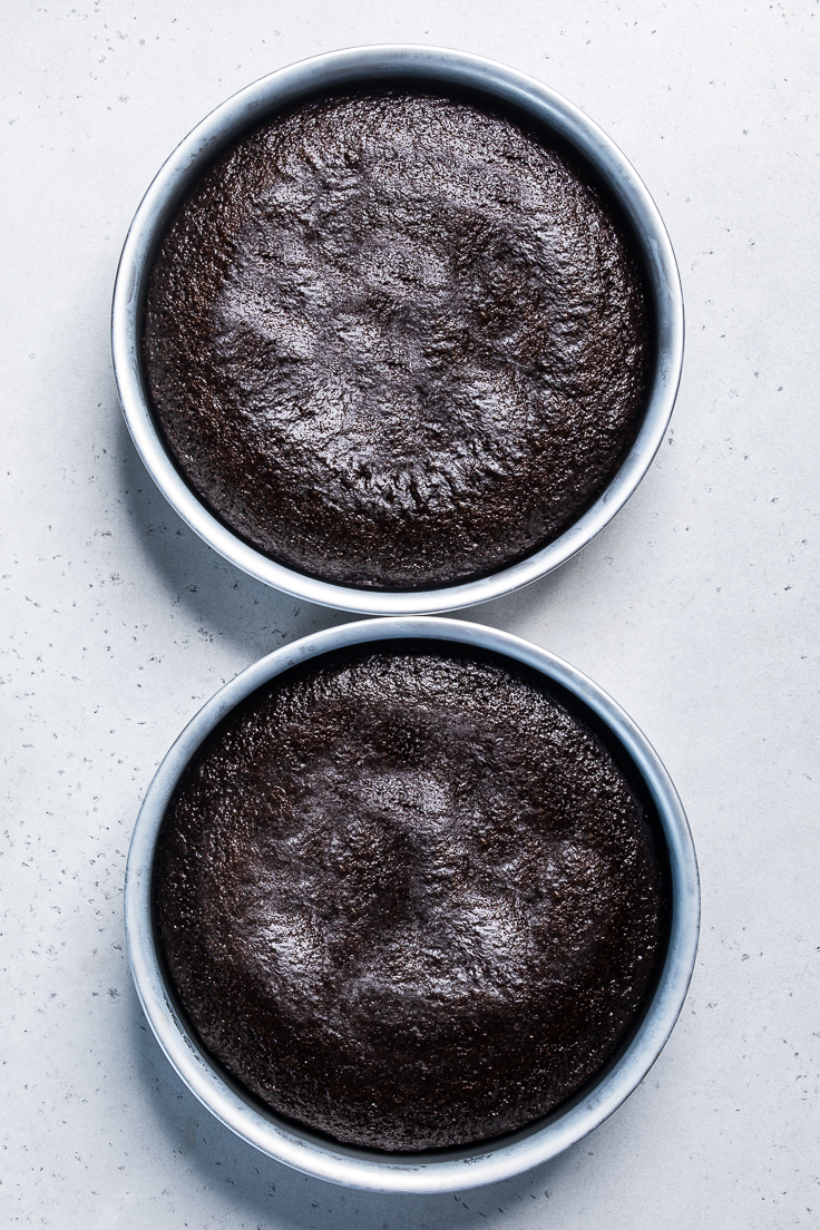 two round pans of cooked chocolate vegan cake. 