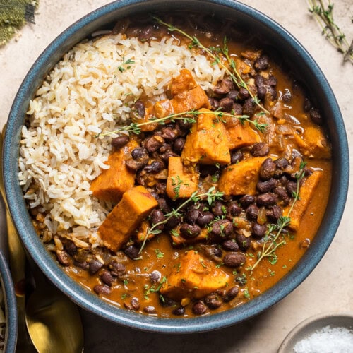 a blue bowl of vegan black bean and sweet potato stew with rice on the left.