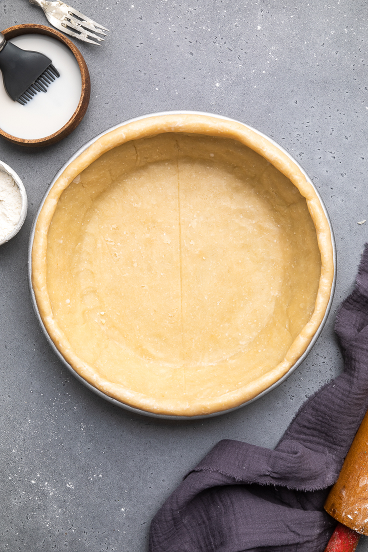 vegan pie crust in a dish with smooth edges. 
