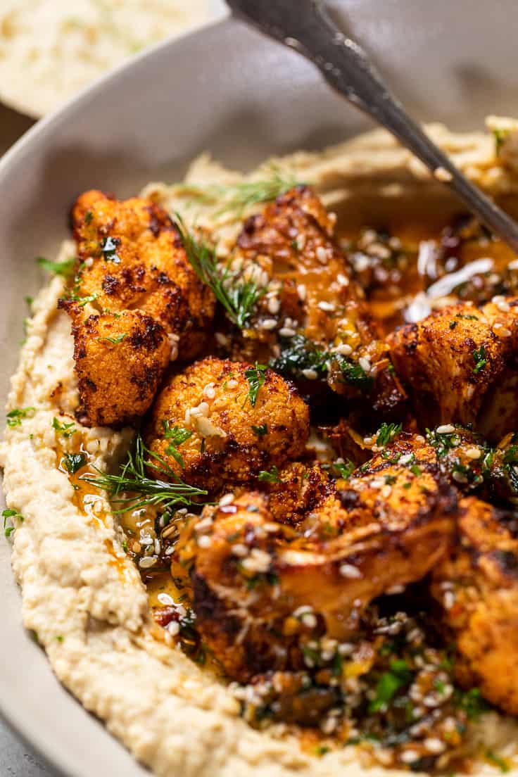close up of spiced cauliflower oven hummus in a bowl.