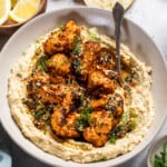 a bowl of spices cauliflower, sauce, and hummus in a bowl.