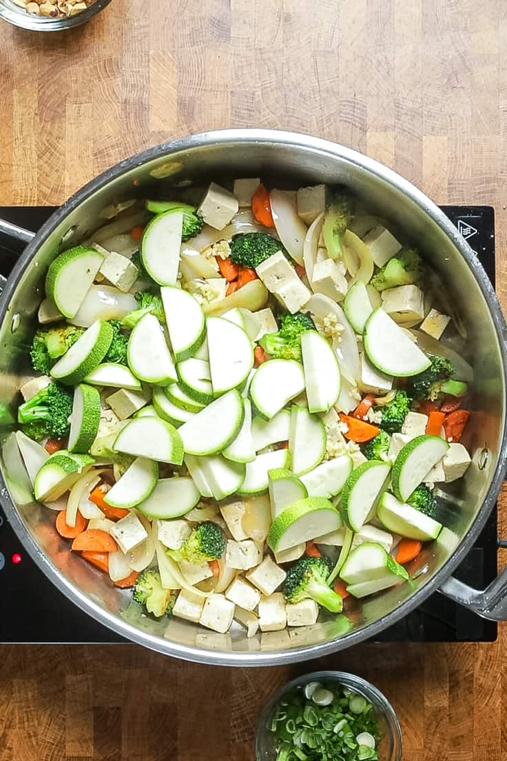vegetables and tofu cooking in a skillet.