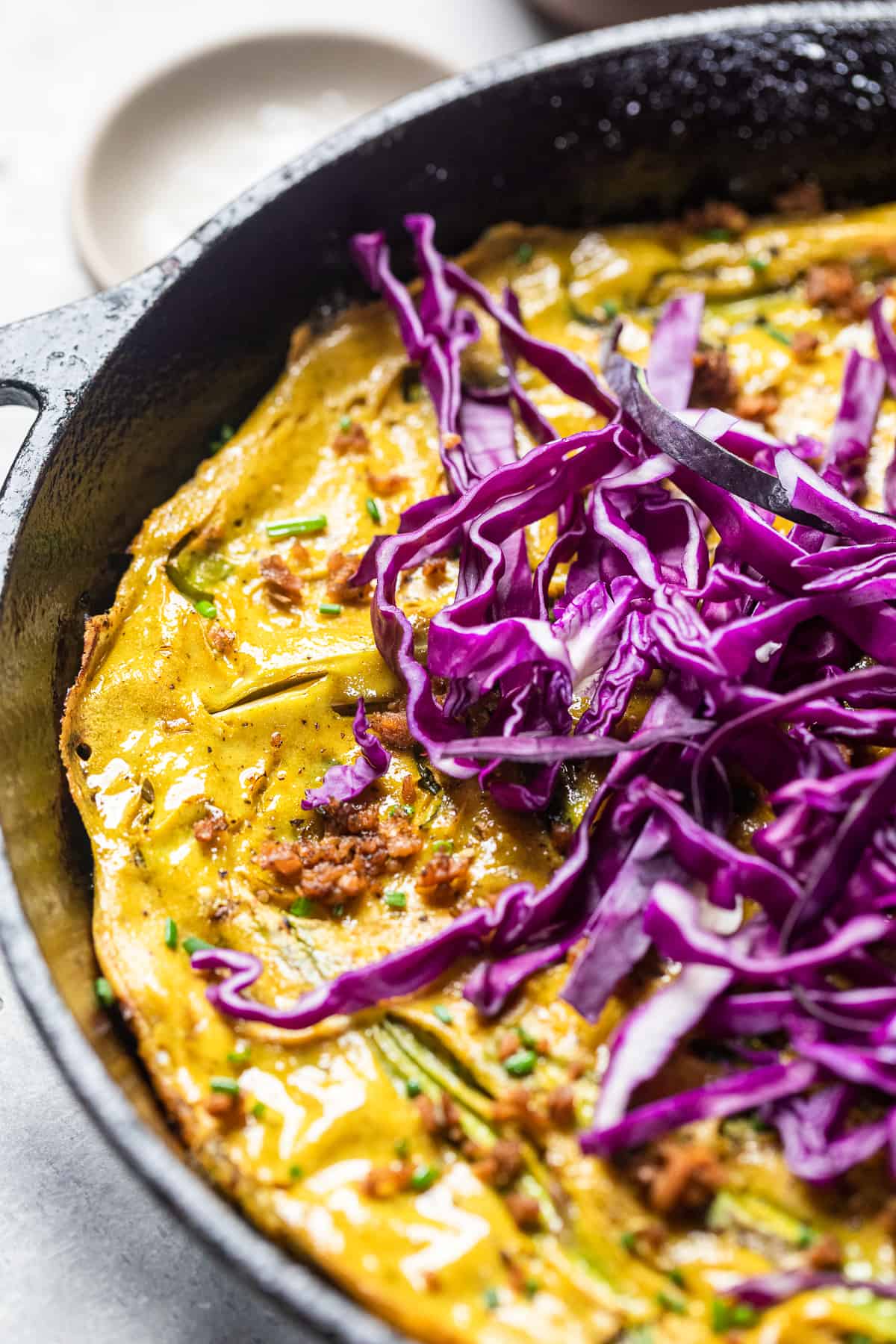 vegan frittata topped with sliced red cabbage.
