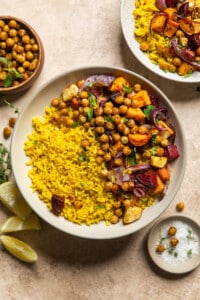 root vegetables, spiced chickpeas, and lemon rice in a bowl on a table.