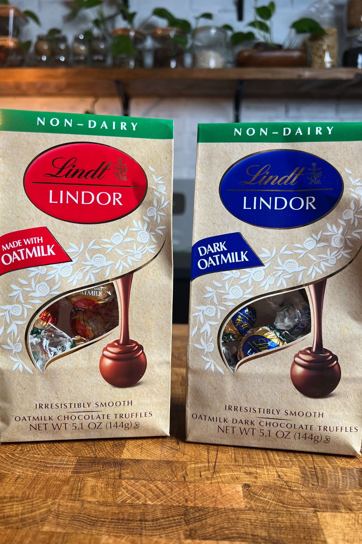 2 packages of lindt lindor non dairy oatmilk truffles side by side on a table.