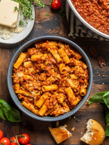 a bowl of rigatoni pasta with lentil bolognese sauce mixed in.