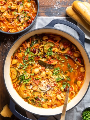 vegan minestrone soup in a dutch oven with a ladle inside.