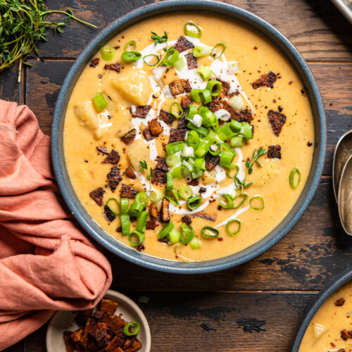 vegan potato soup with bacon bits and green onions on top.