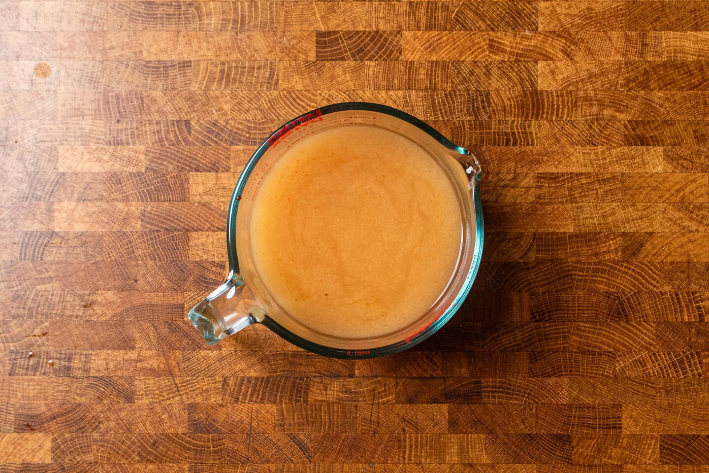 a glass measuring cup with vegetable stock and miso.