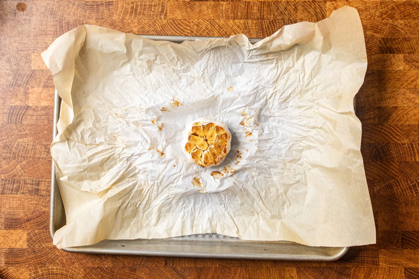 Roasted garlic bulb on a piece of parchment paper.