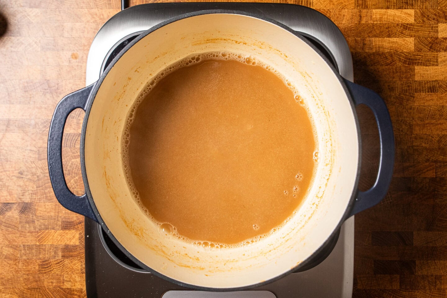 a pot of stock and roux starting to make a gravy.