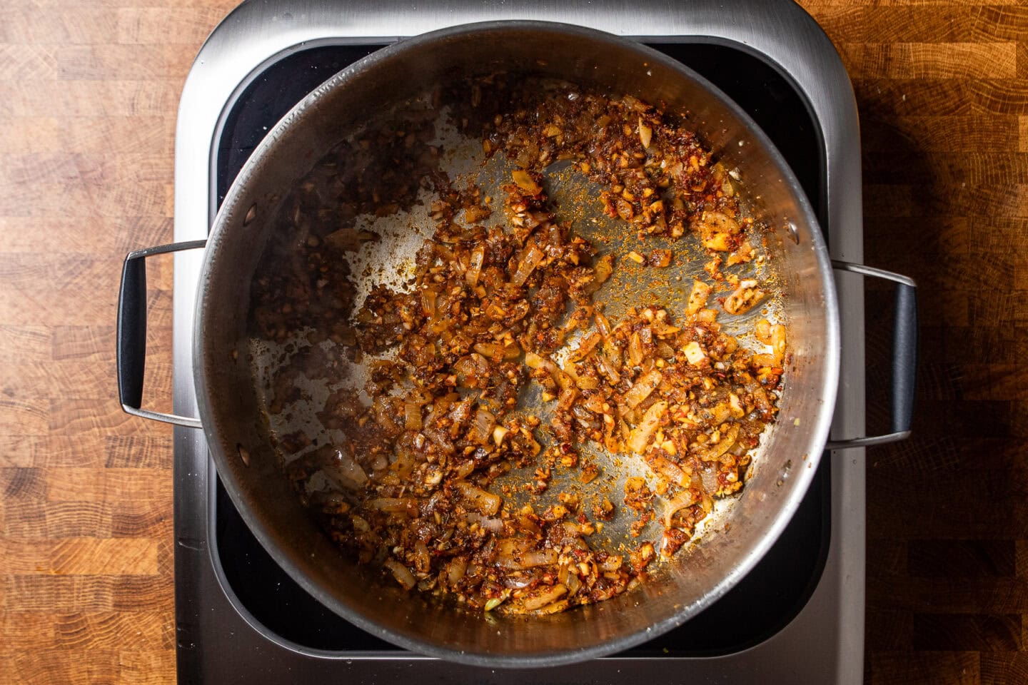 onions garlic and spices cooking in a skillet.
