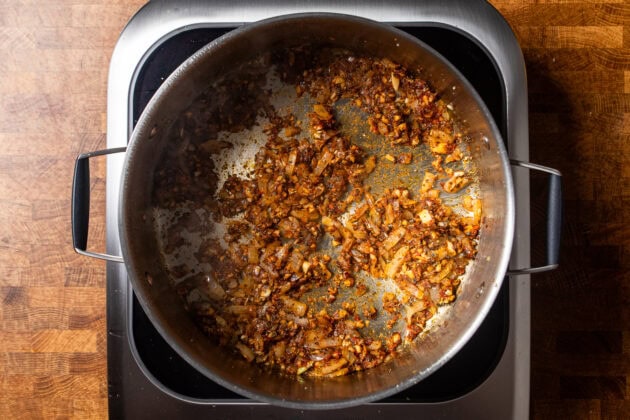 onions garlic and spices cooking in a skillet.