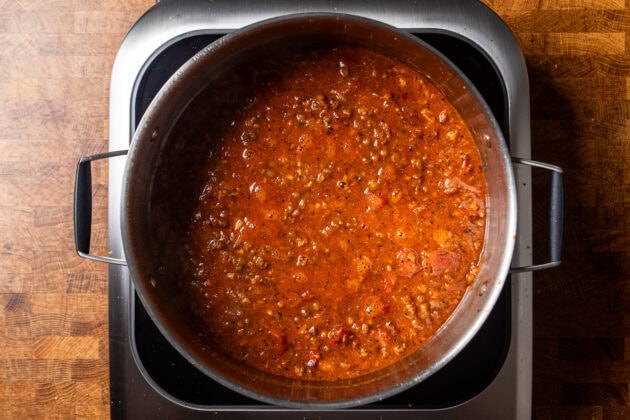 brown lentils cooking in a tomato based sauce.