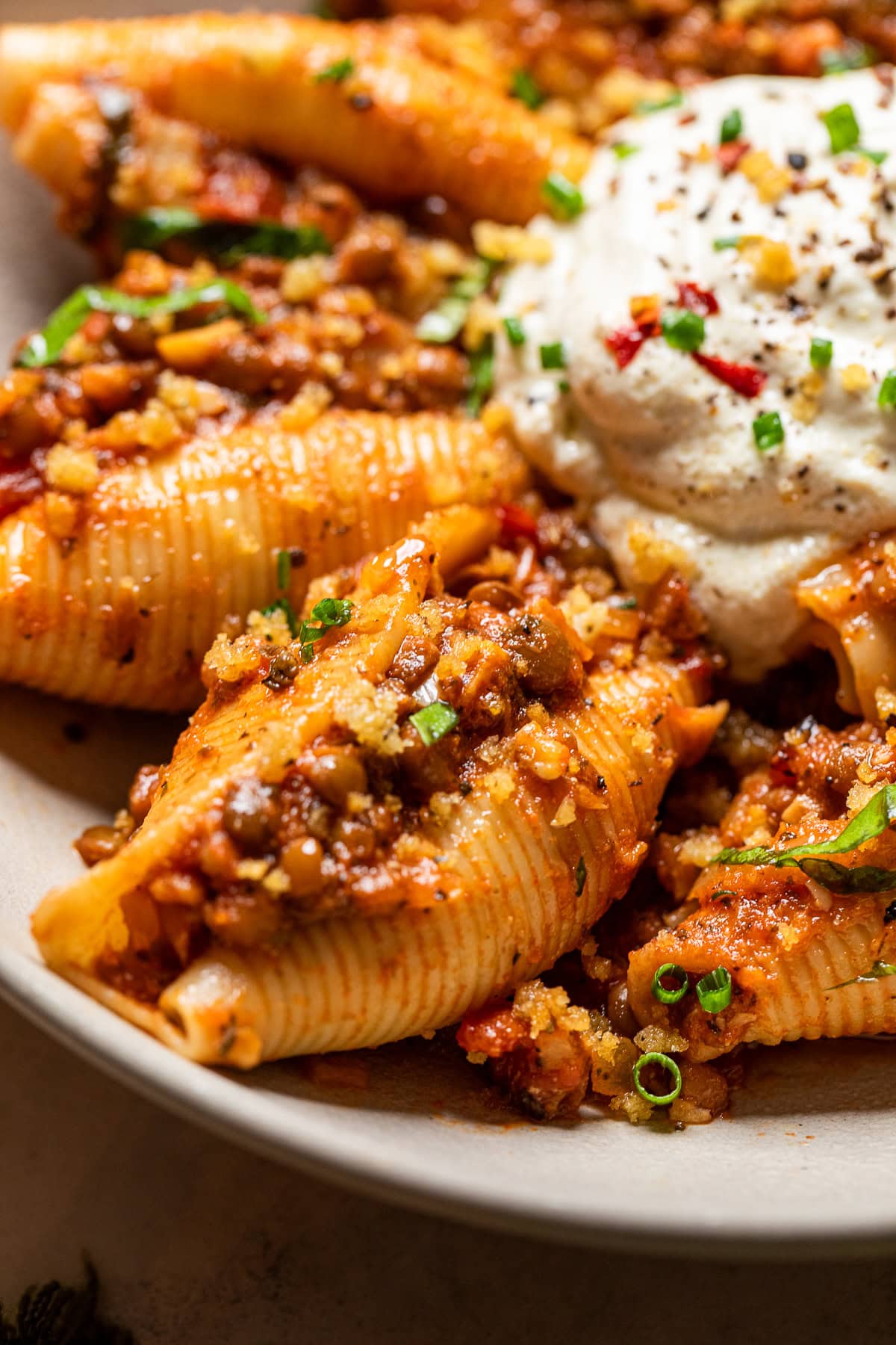 close up of jumbo pasta shells with a vegan filling and sauce. 