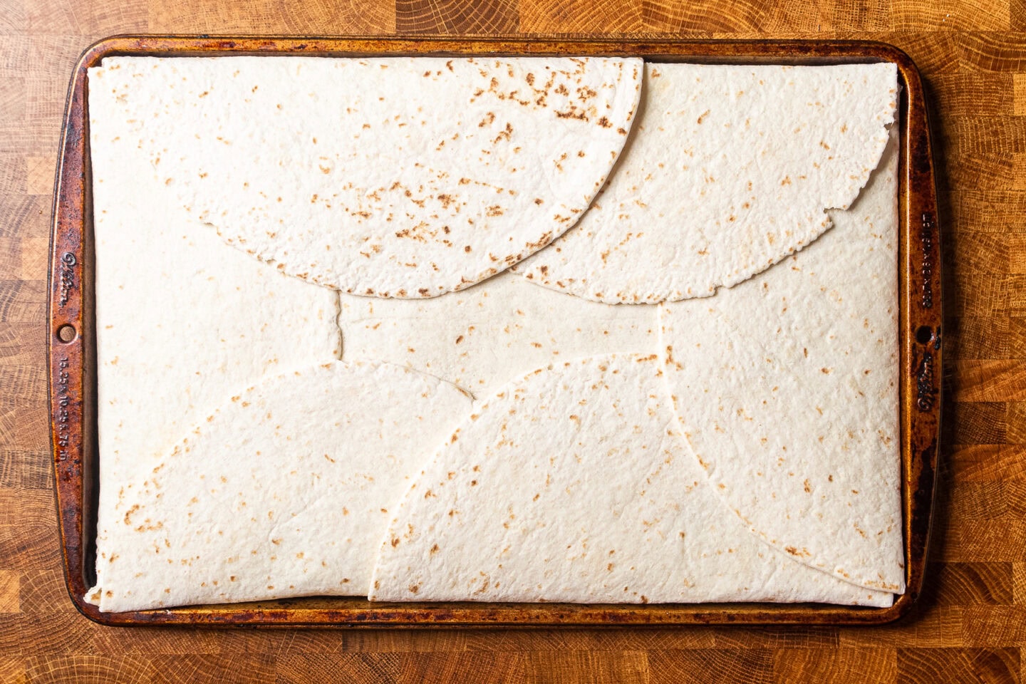 an uncooked sheet pan quesadilla on a baking tray.
