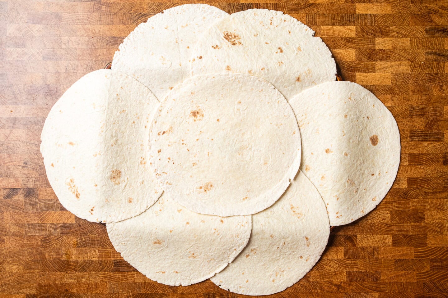 tortillas laid out to make a sheet pan quesadilla before adding the filling.