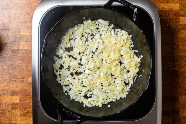 a cast iron skillet of yellow onions sauting.