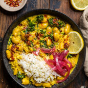 a skillet of warmed zesty butter beans with rice and pickled red onions.