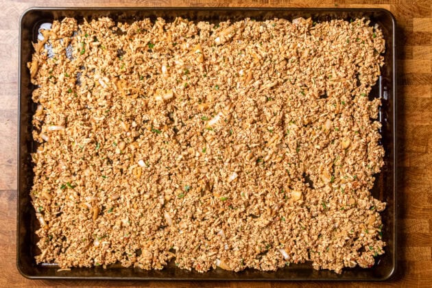seasoned tofu crumbles on a baking sheet before being baked.