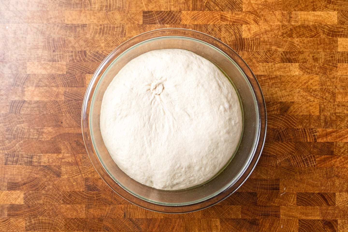 dough rising in a glass bowl.
