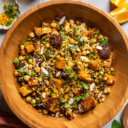roasted sweet potato citrus moroccan-couscous salad in a wooden bowl.
