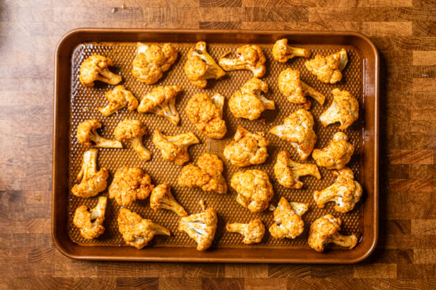 seasoned baked cauliflower on a copper baking tray.