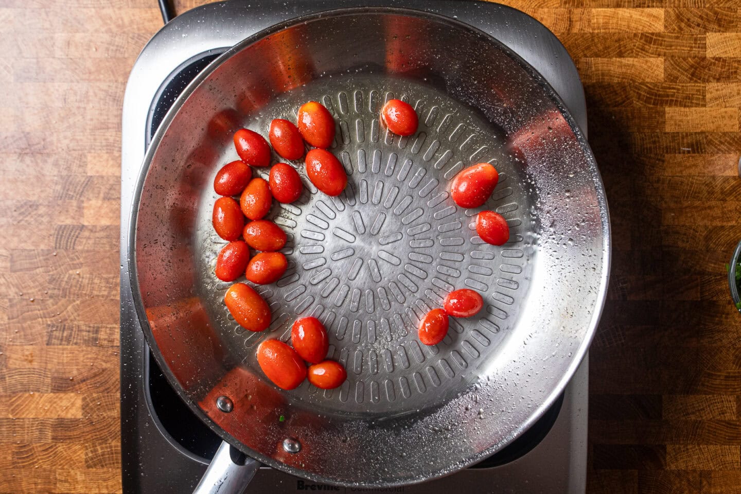 cherry tomatoes cooking in a skillet.
