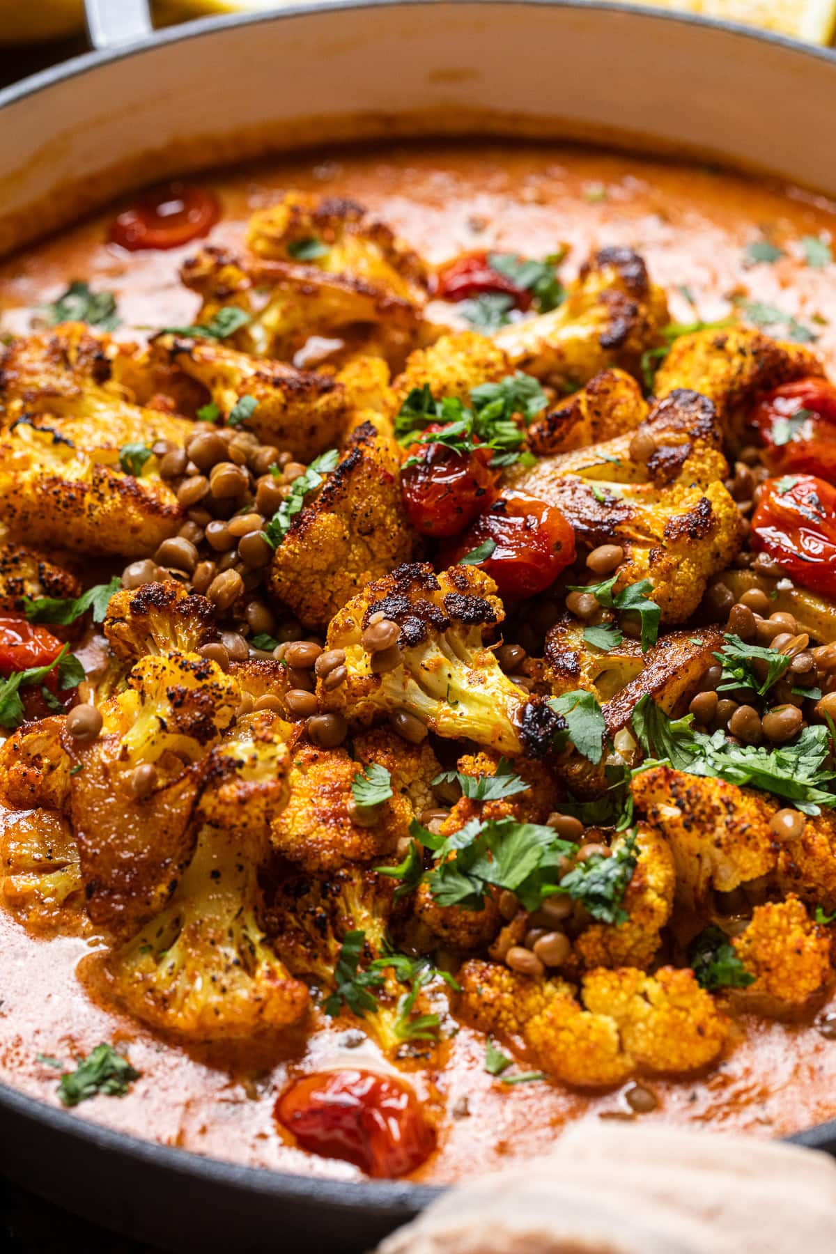 close up of roasted cauliflower and lentils with a creamy coconut tomato sauce.