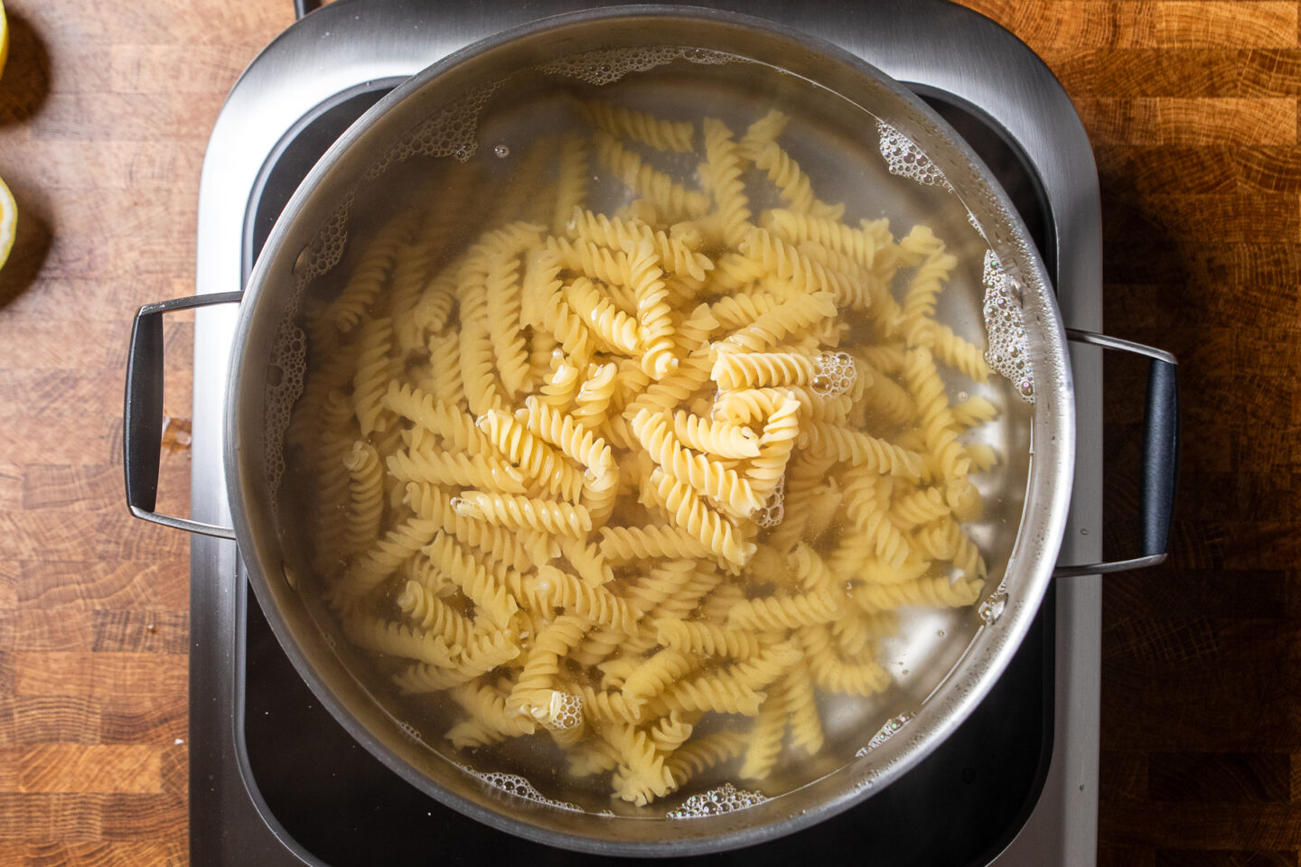 pasta cooking in a large stainless steel pot.