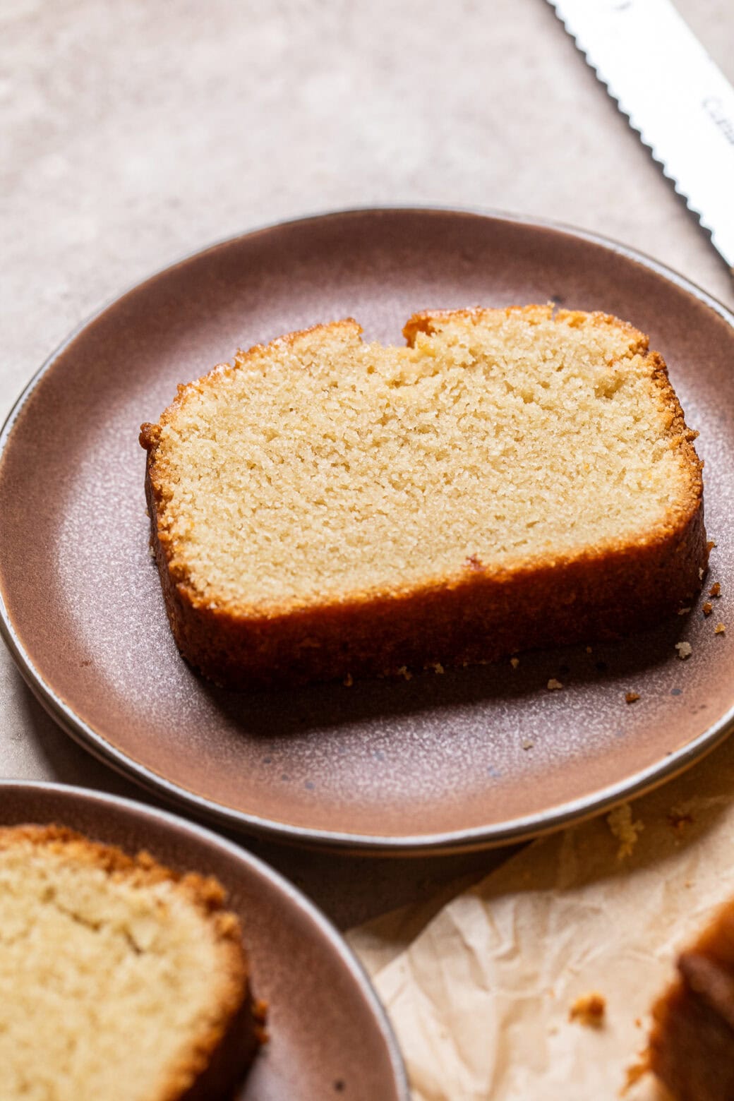 a slice of vegan pound cake on a brown plate.