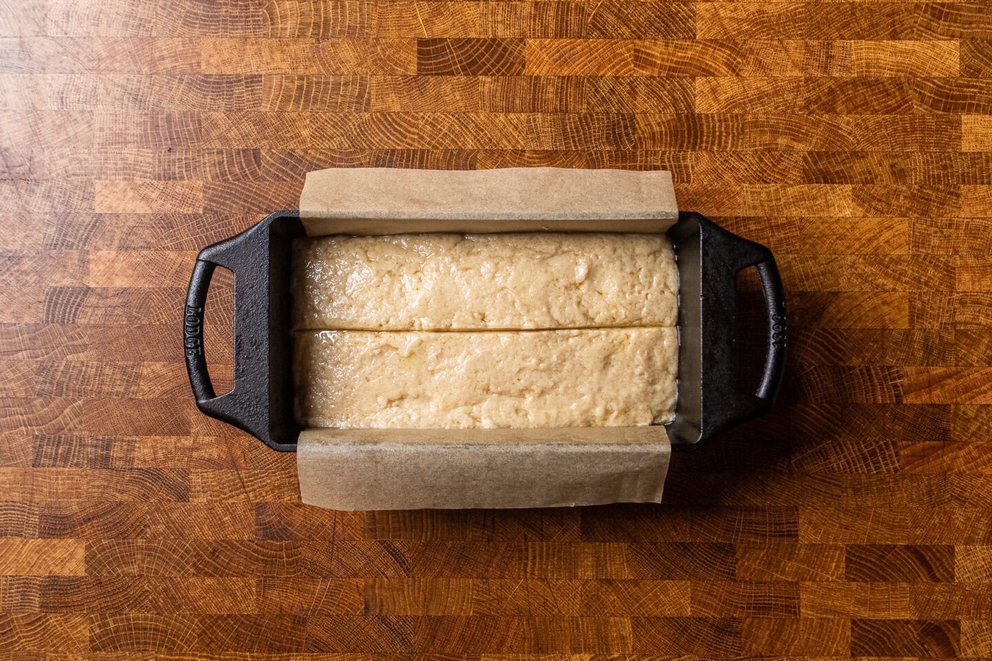 uncooked vegan pound cake in a cast iron loaf pan.