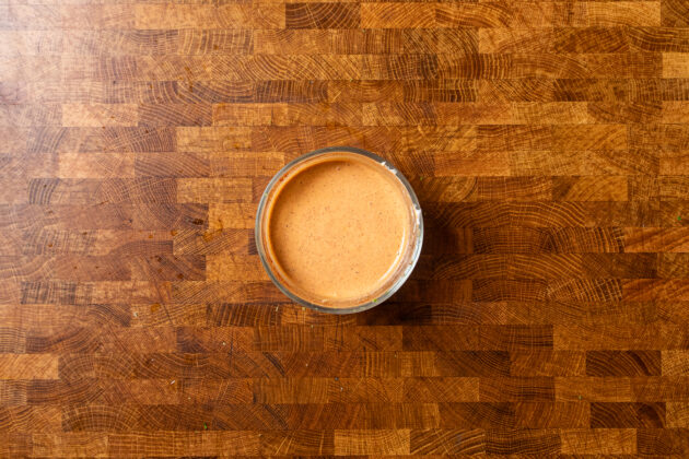 elote sauce in a jar on a table.