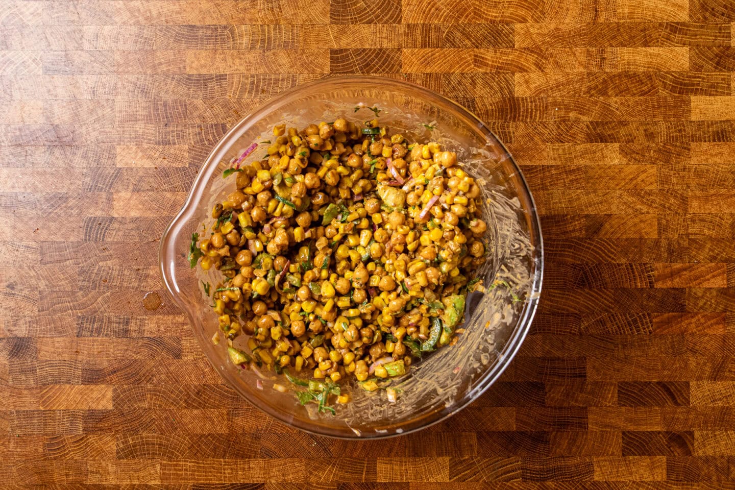 a large glass bowl filled with mexican street corn salad.
